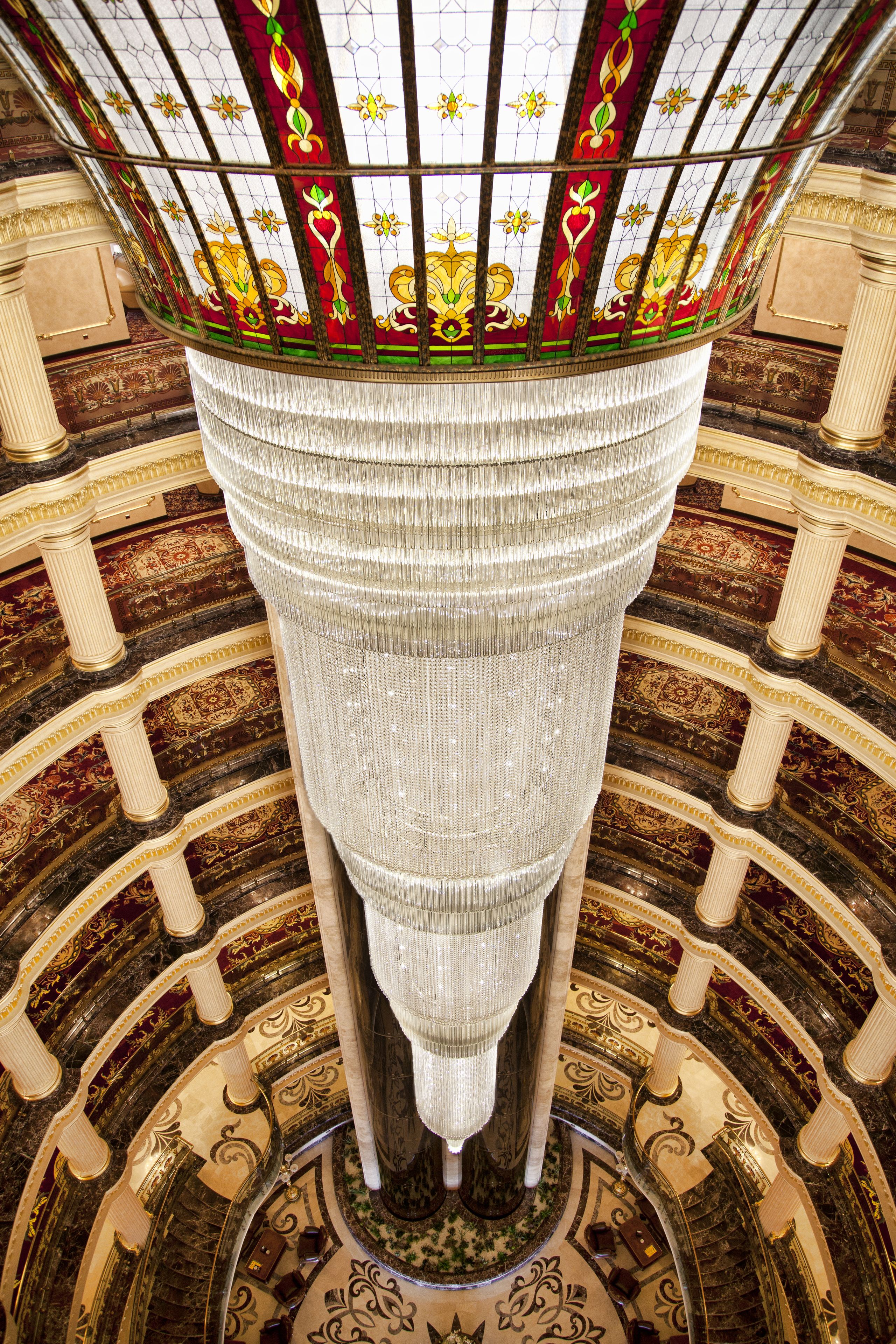 A grand, ornate interior with a large, decorative ceiling and intricate floor patterns.