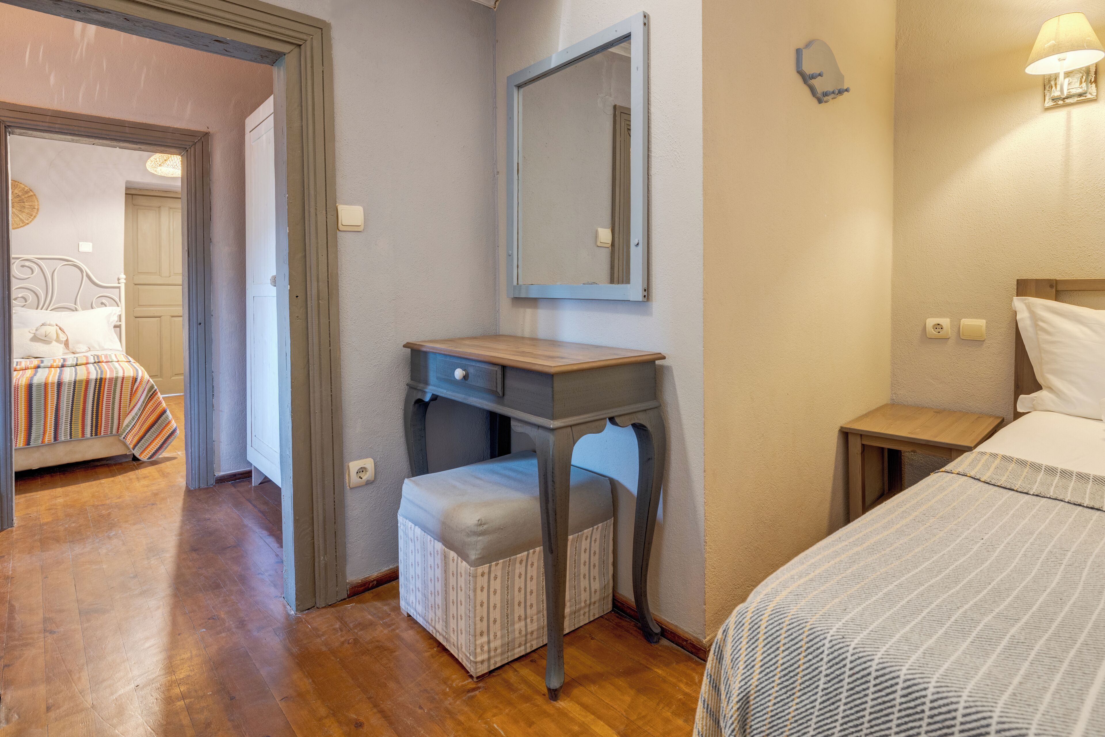 Une chambre à coucher avec un lit, une table de chevet et un miroir.