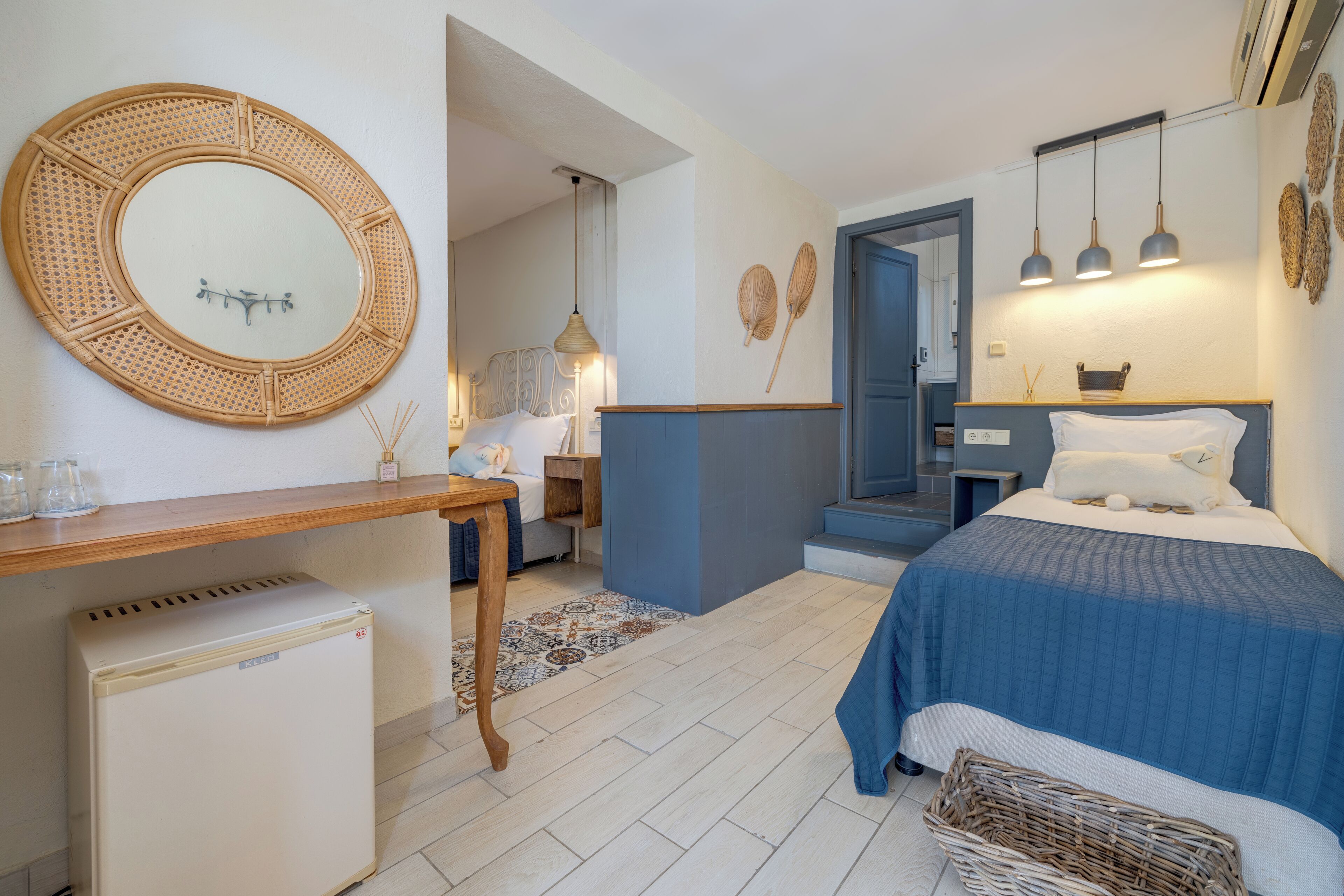 A bedroom with a bed, bedside table, and a small refrigerator.