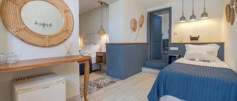 A bedroom with a bed, bedside table, and a small refrigerator.