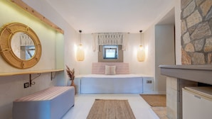 A bedroom with a bed, bedside table, and a large mirror on the wall. - Aral Tatil Ciftligi (Bozcaada)