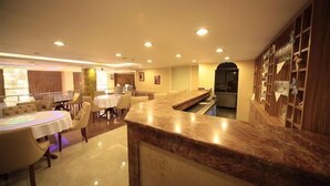 A hotel lobby with a marble reception desk, round tables, and chairs. - Simper Hotel (Istanbul)