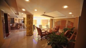 A hotel lobby with a reception desk, seating area, and a large pillar. - Simper Hotel (Istanbul)