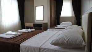 A hotel room with a large bed, a smaller bed, a desk, and a mirror. - Simper Hotel (Istanbul)