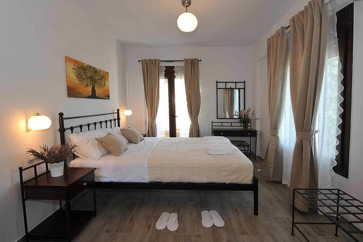 Ein Schlafzimmer mit einem Bett, einem Nachttisch, einer Lampe und einem Spiegel.