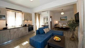 A modern apartment with a kitchen, living area, and dining space. - OLIVIA VILLAS (Ikaria)