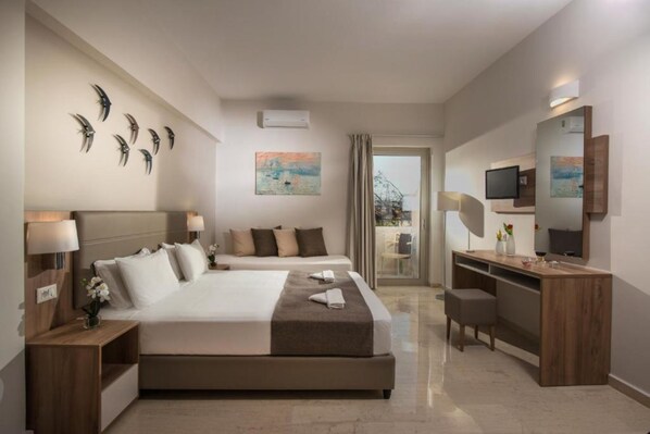 A modern hotel room with a large bed, a desk, and a balcony with a view. - Marianthi Apartments by Estia (Rethymno)