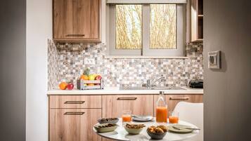 A kitchen with wooden cabinets, a tiled backsplash, a window with bamboo view, and breakfast items on the counter.