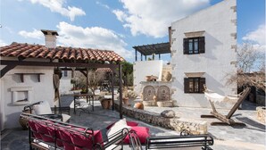 A courtyard with outdoor seating, a pergola, and a stone fountain. - Villa Tzivaeri (Chania)