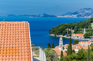A coastal town with terracotta roofs, a prominent church, and a clear view of the sea. - Cina Apartments (Konavle)