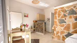 Una habitación con comedor, cocina y una pared de acento de piedra.