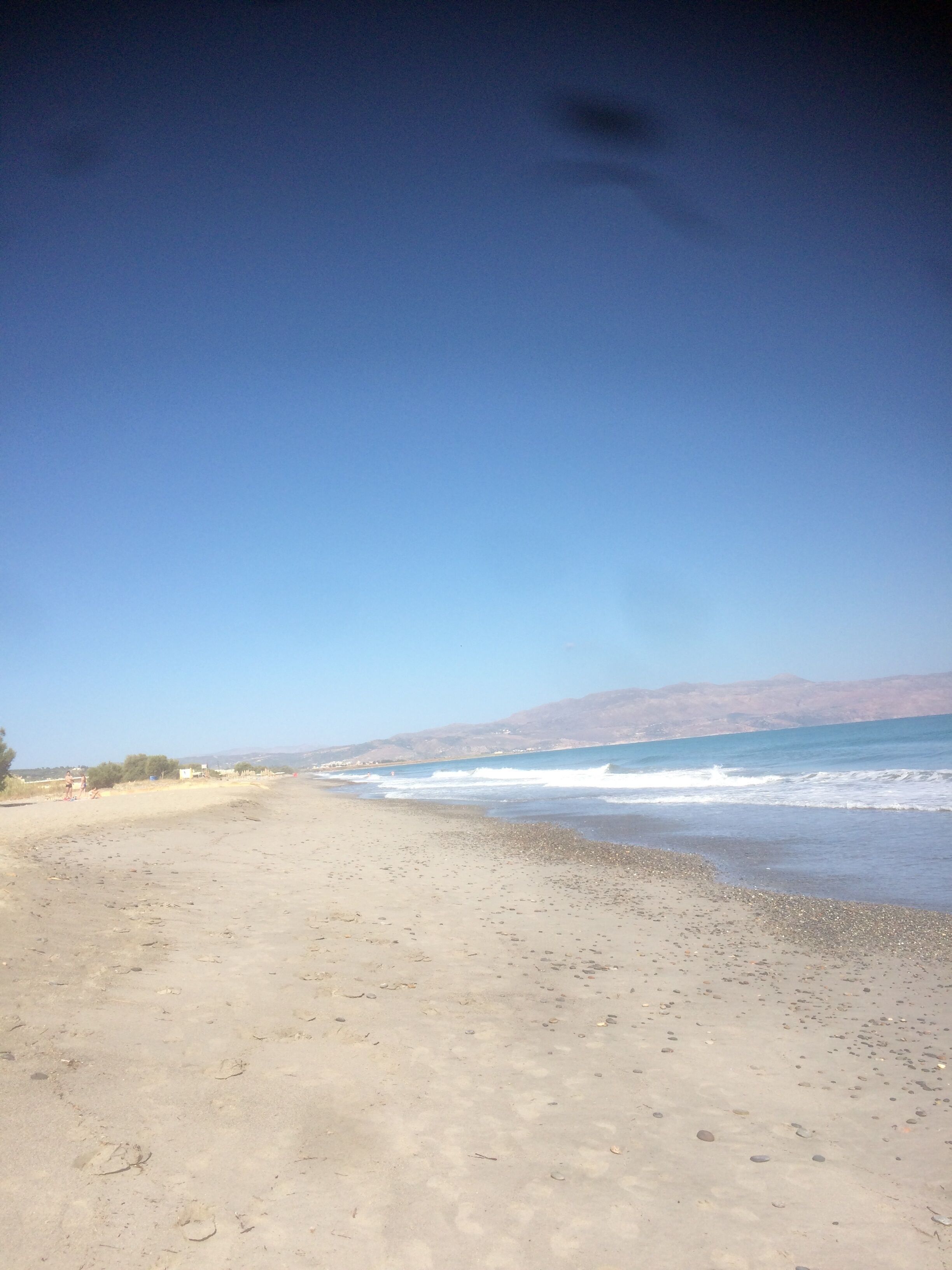 A beach with a clear sky and calm sea.