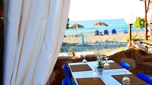 Un área de comedor al aire libre con vista a la playa y el océano.
