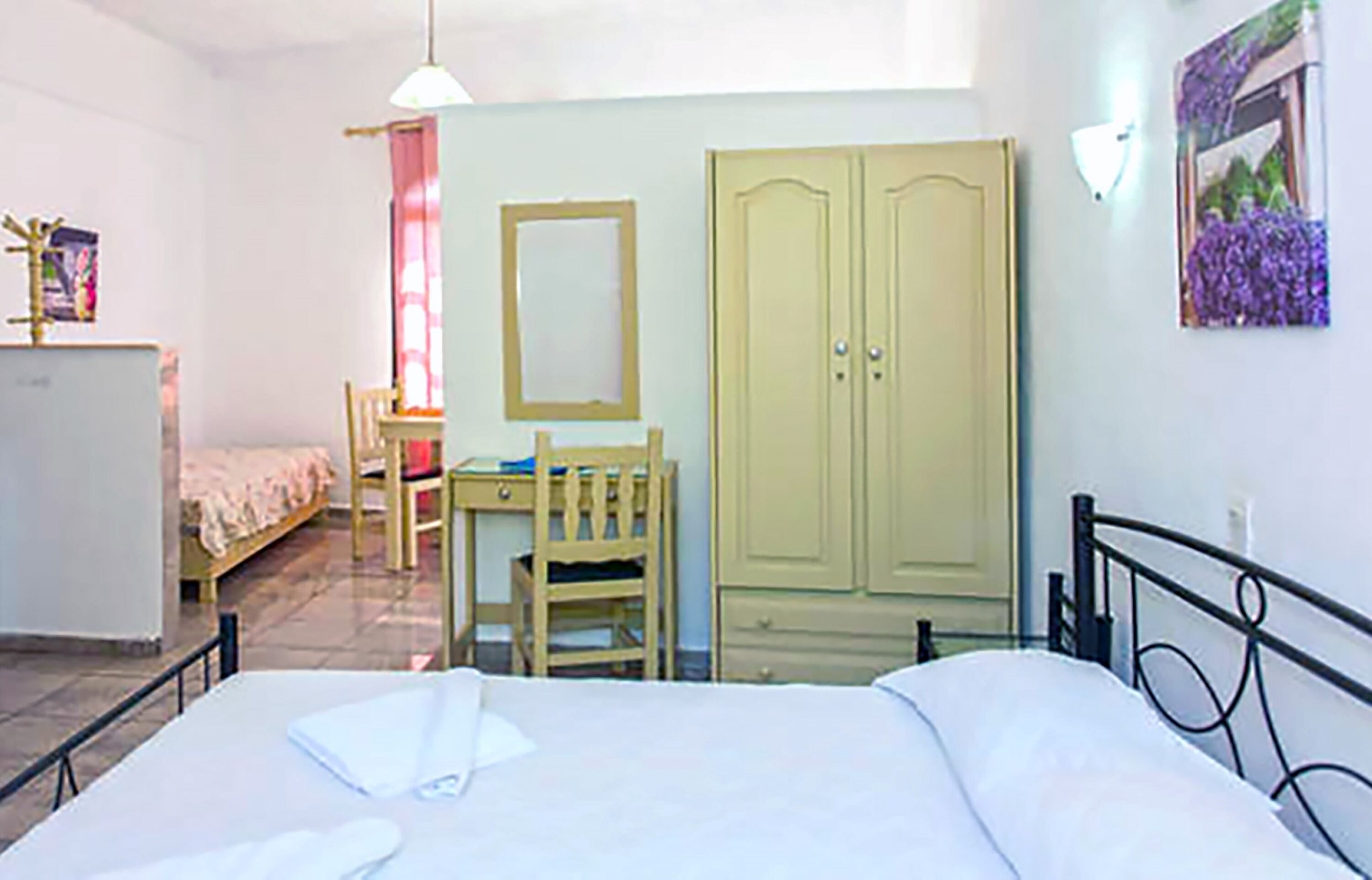 Una camera da letto con un letto, una scrivania, una sedia e un armadio.