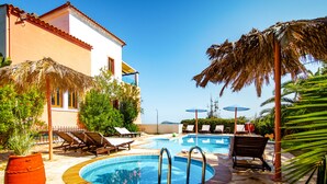 A pool area with lounge chairs and a palm tree.