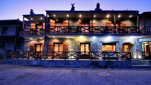 A two-story stone building with balconies and wooden railings. - Guesthouse Teloni (Gortynia)