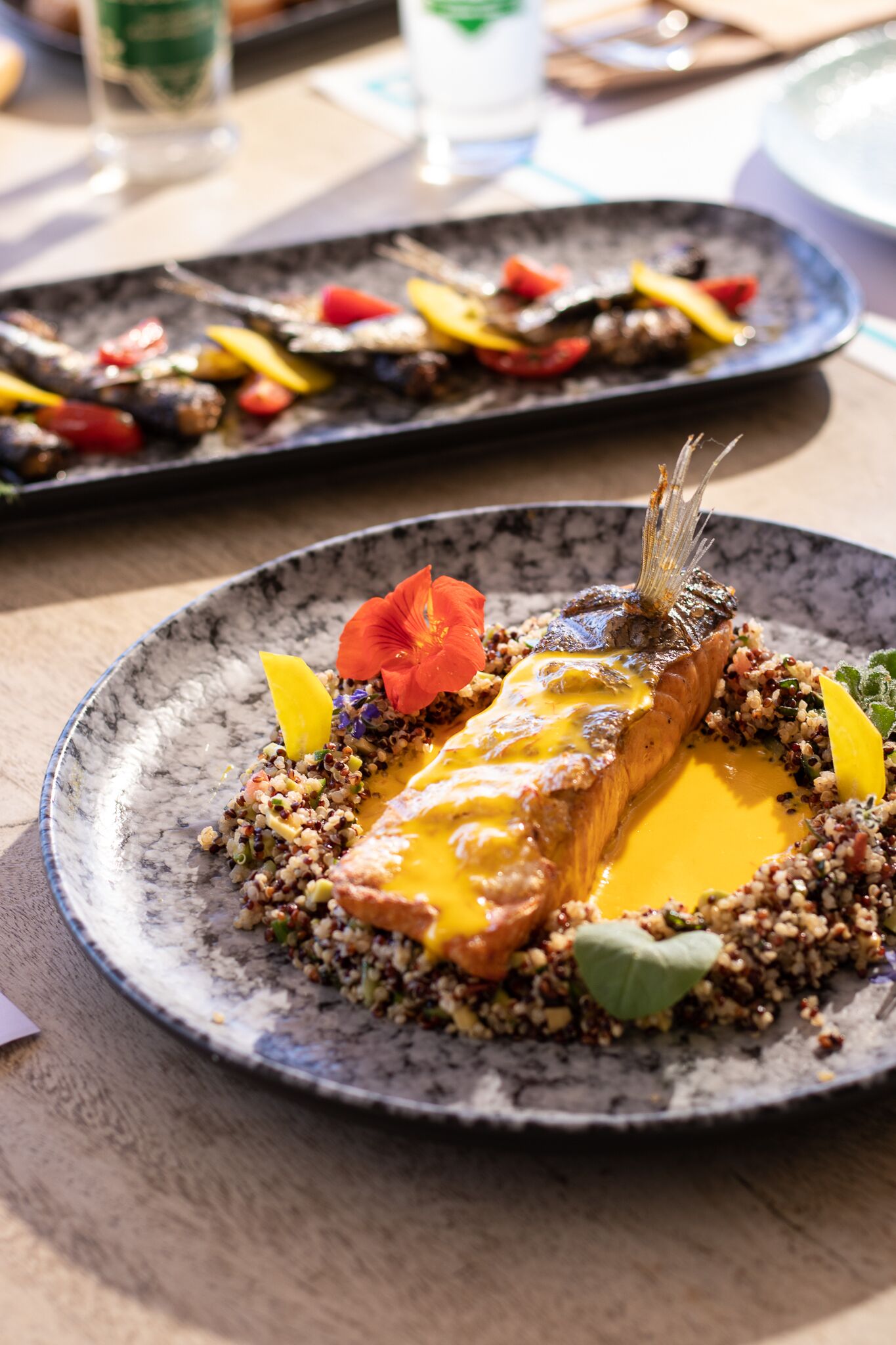Ein Teller mit Lachs, Quinoa und Gemüse.