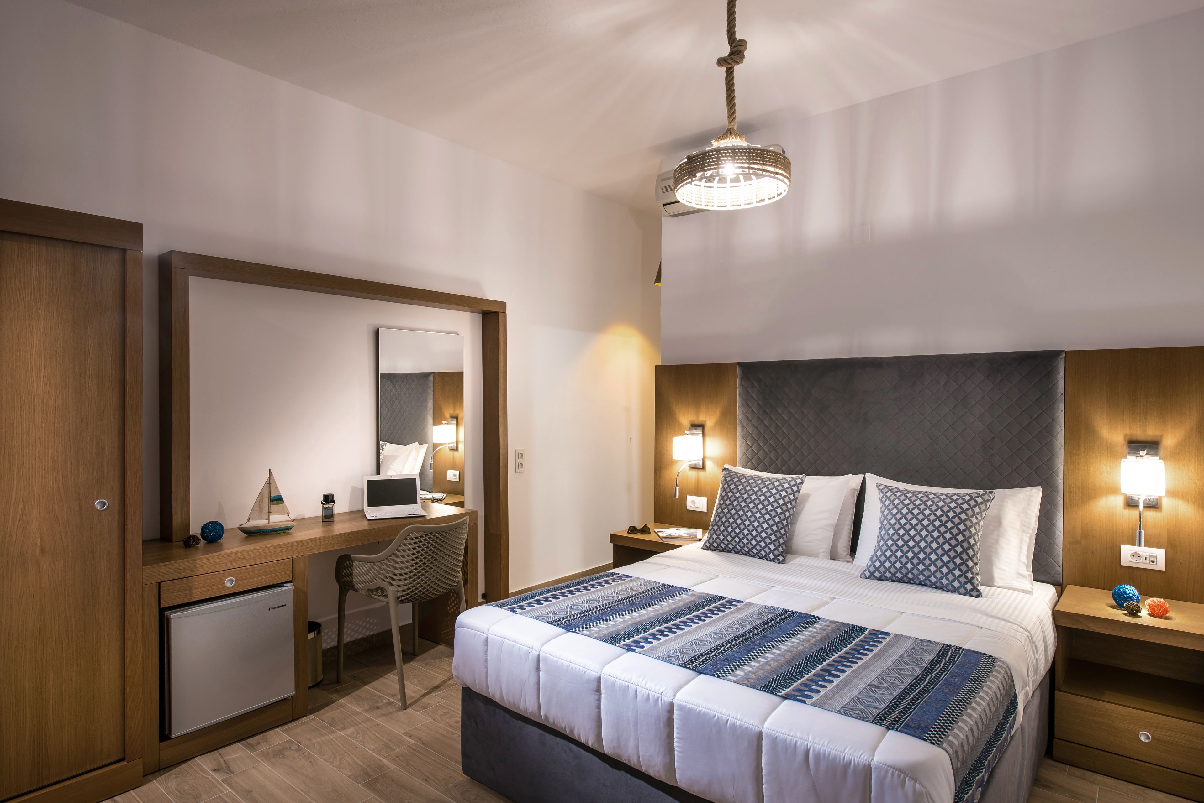 A hotel room with a bed, desk, and wardrobe.