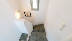 A staircase with stone steps and a white wall. - Maisons a la Plage (Sifnos)