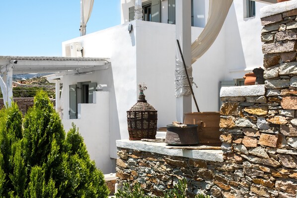 A white building with stone walls and a pergola.