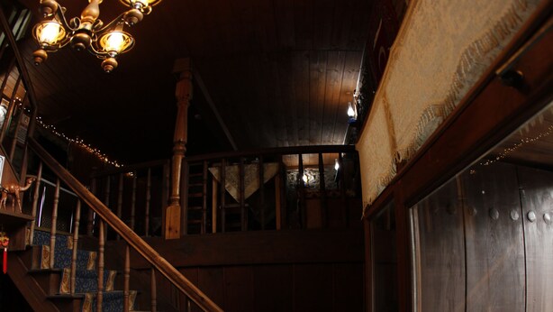 A wooden staircase with a chandelier, a door labeled "CEKINZ," and potted plants near the entrance. - Arifbey Konak Hotel (Safranbolu)