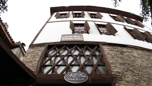 The entrance of the Konak Hotel with a traditional wooden facade and a sign indicating the name. - Arifbey Konak Hotel (Safranbolu)