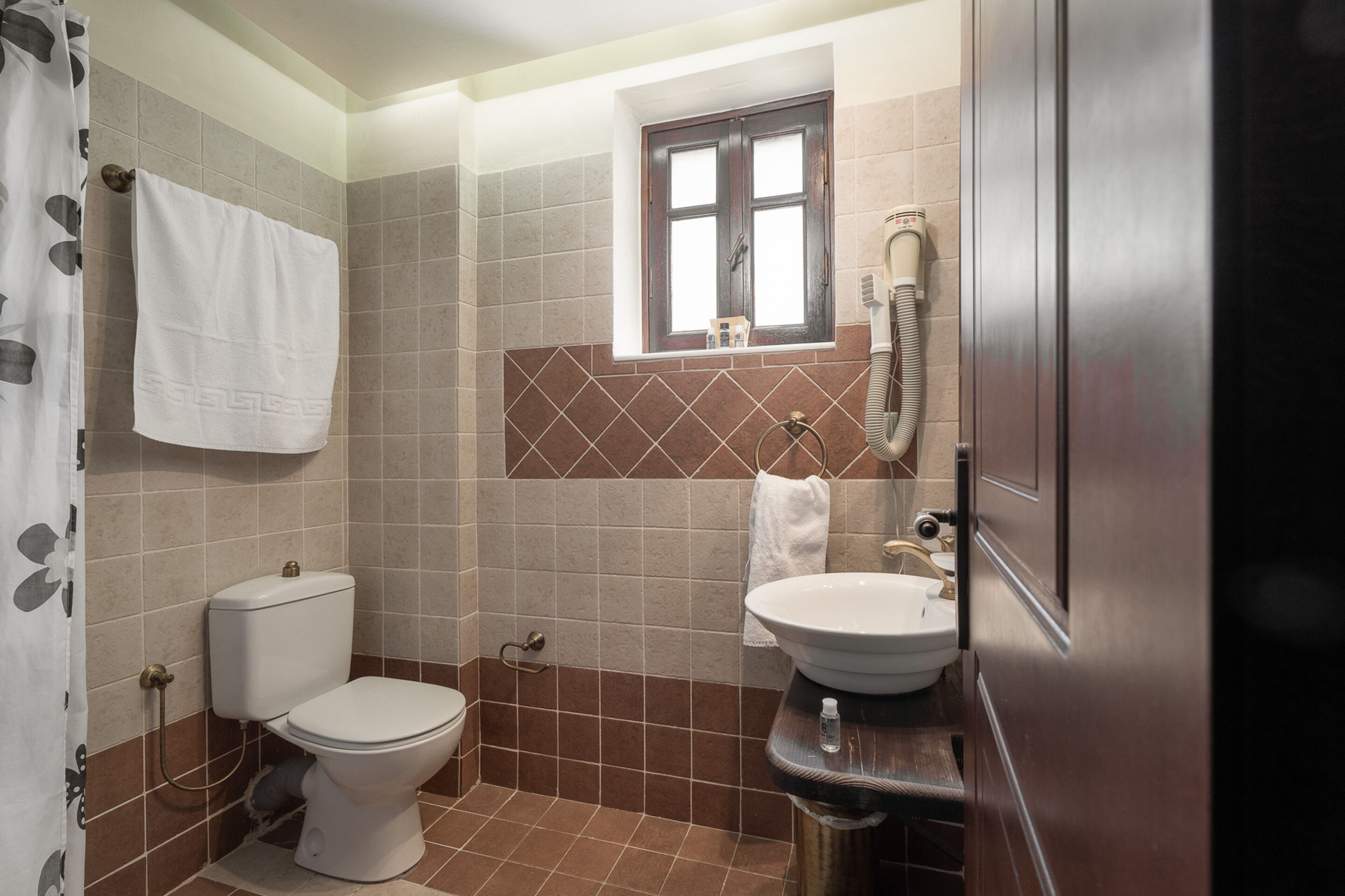 Un baño con inodoro, lavabo y ducha.