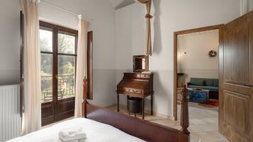 Un dormitorio con una cama grande, un aparador de madera, un espejo y vistas al exterior a través de una ventana.