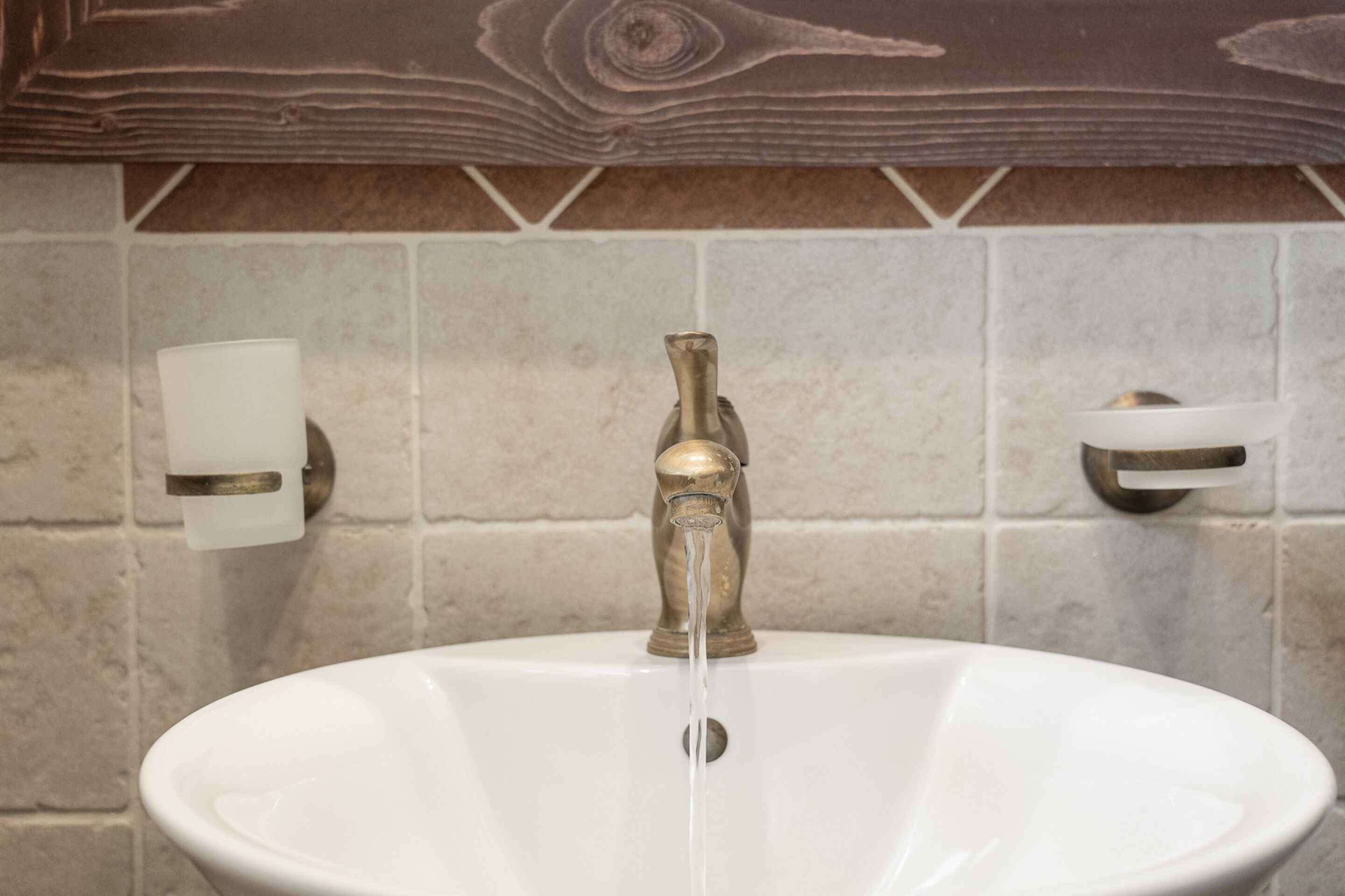 A bathroom sink with a brass faucet and a white basin.