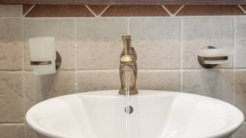 A bathroom sink with a brass faucet and a white basin.