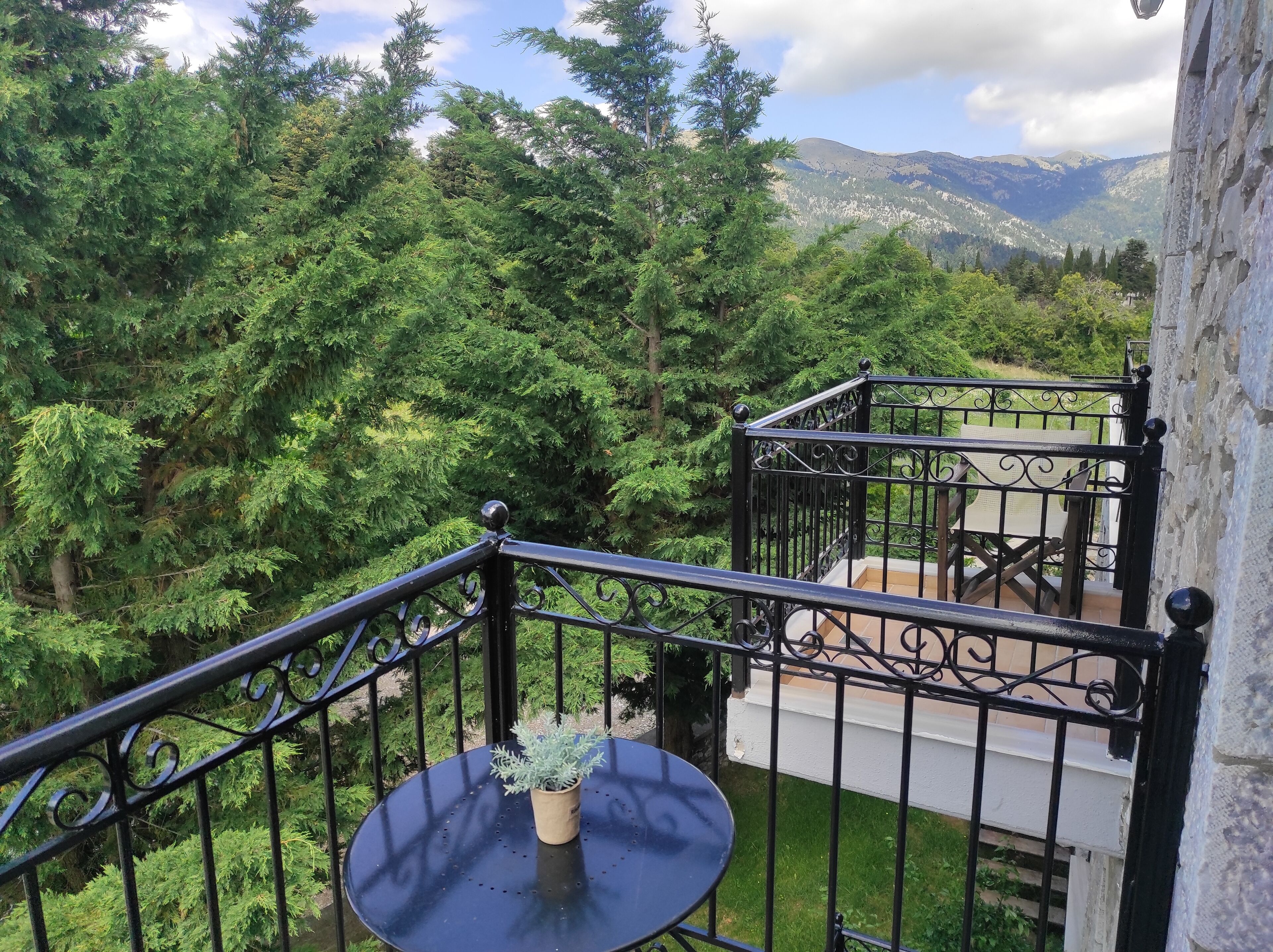 A balcony with a view of dense forest and mountains.