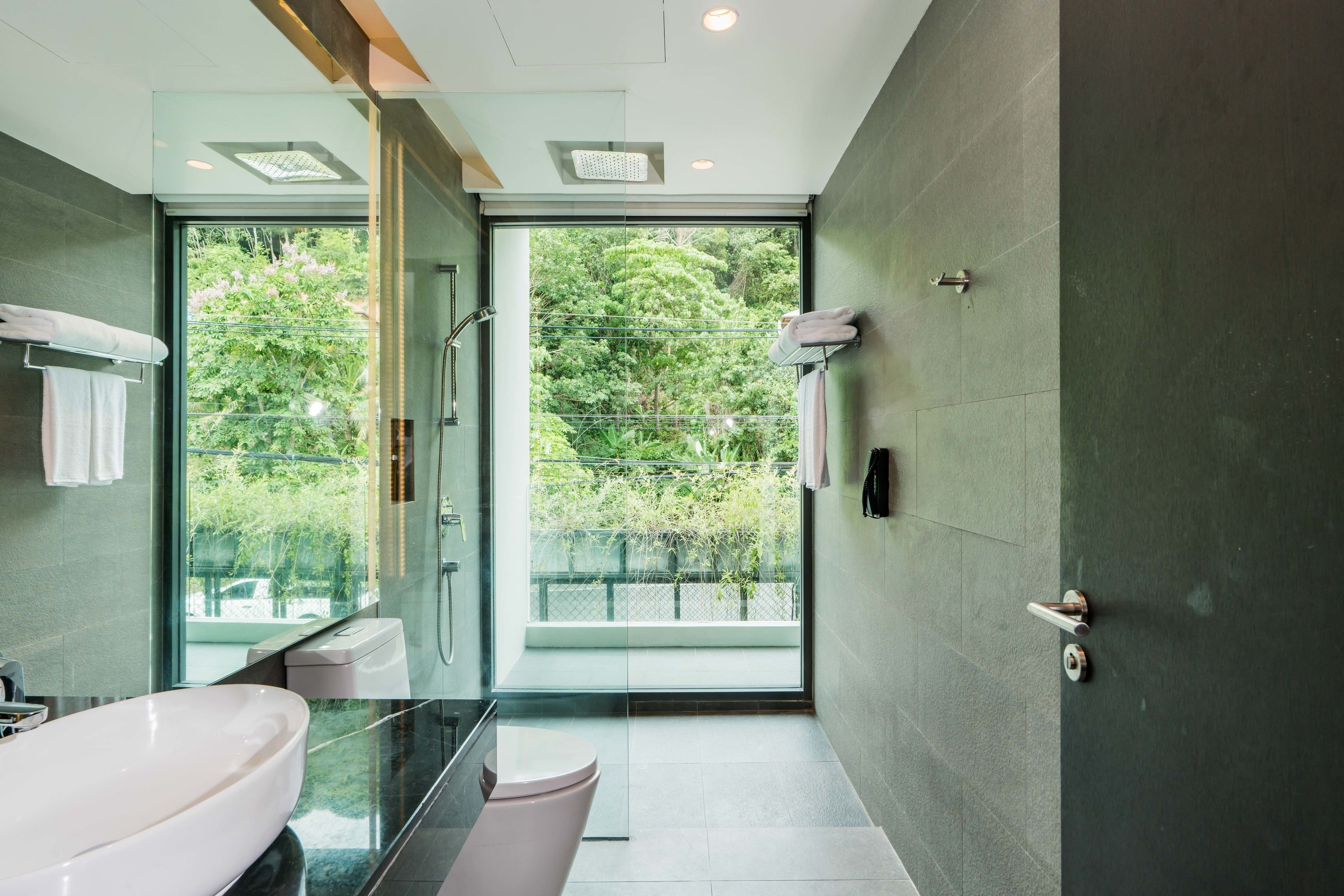 Une salle de bain moderne avec une douche à parois de verre, un grand lavabo et des toilettes.
