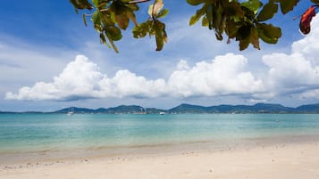 En la playa, sombrillas, toallas de playa y yoga en la playa