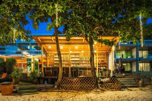 A beachside building with a wooden deck, potted plants, and a fence. - My Beach Resort Phuket (Wichit)
