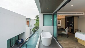 A modern bathroom with a freestanding bathtub, a glass-enclosed pool, and a seating area with a cushion. - My Beach Resort Phuket (Wichit)
