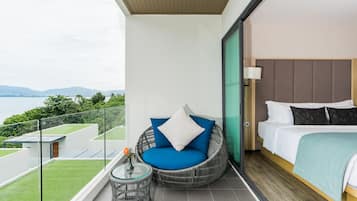 A balcony with a wicker chair, a small table with a vase, and a bed with a headboard.