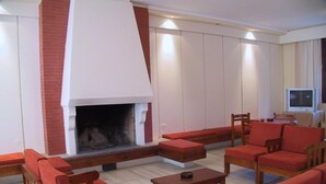 Una sala de estar con chimenea, muebles de madera y televisor.