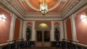 A grand entrance with a marble floor, ornate ceiling, and statues flanking the doors. - Casual Blue (Bilbao)