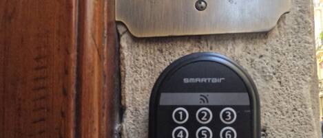 A keypad door lock with a 'CASUAL' sign above it, mounted on a textured wall.
