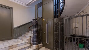 A staircase with marble steps leading to a door with a metal gate. - Casual Blue (Bilbao)