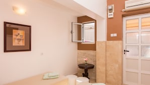 A bathroom with a bathtub, a sink, a mirror, and a towel rack. - Guest House Cuk (Dubrovnik)
