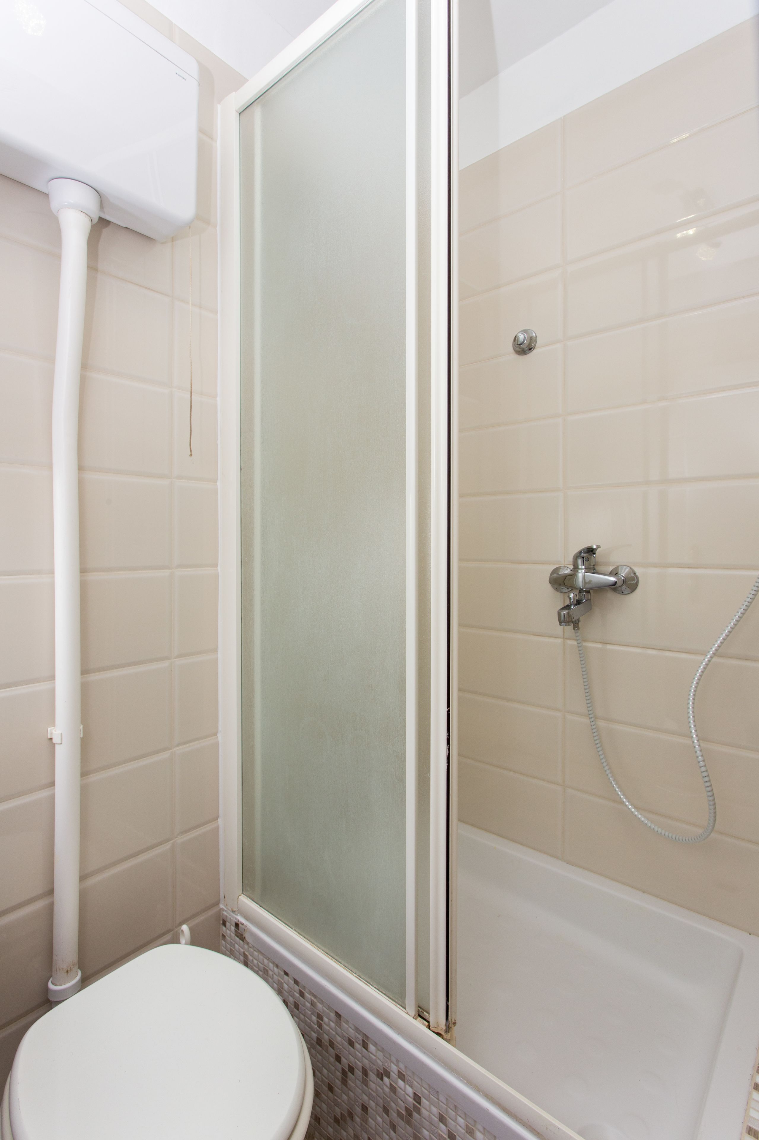 Een badkamer met toilet, douchecabine en bad.