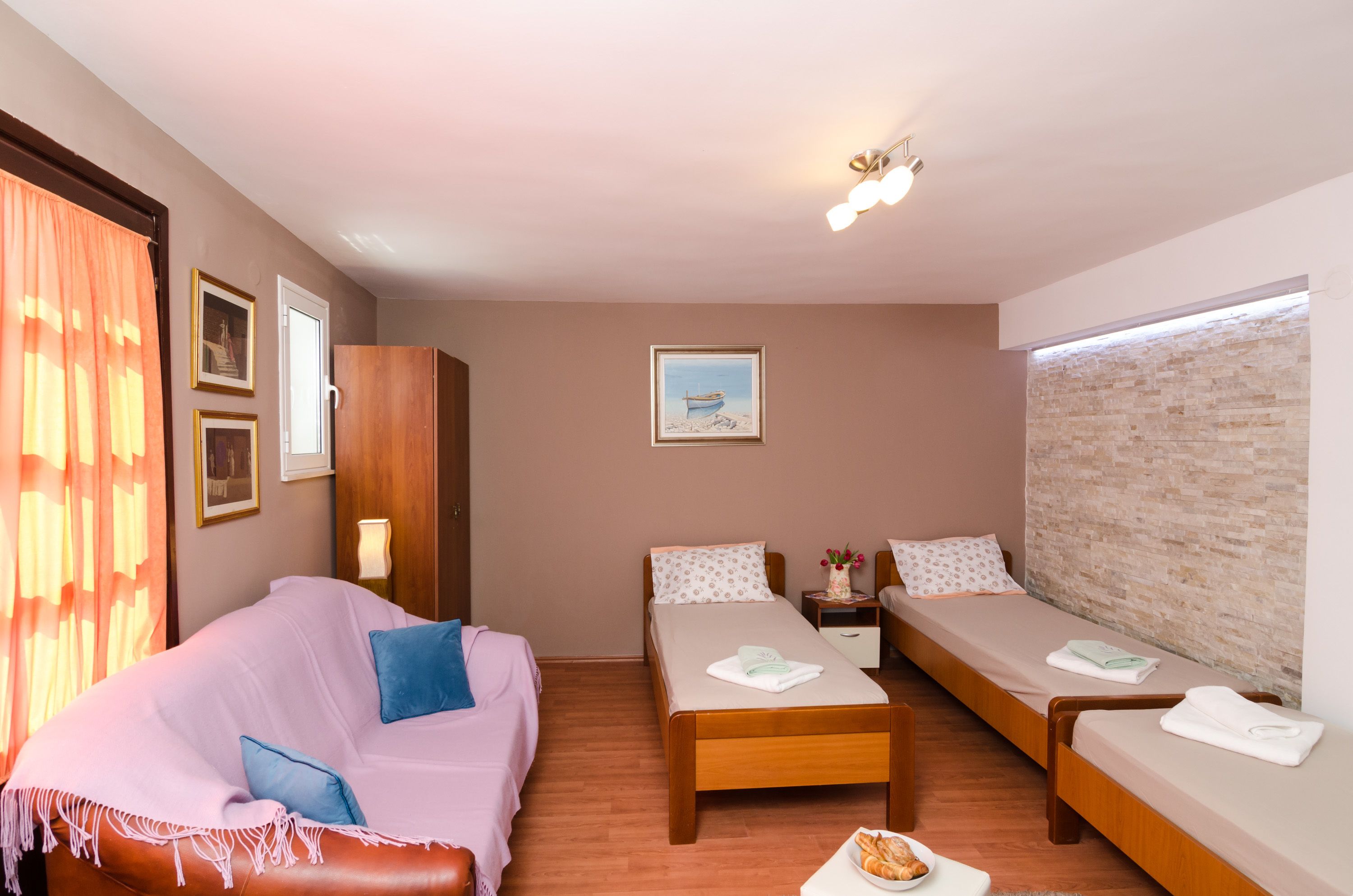 Una habitación con cama, sofá, una mesita y ventana con vistas.
