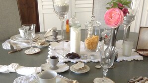 A dining table set with fine china, glassware, and a centerpiece. - La Maison du Phare B&B (Honfleur)