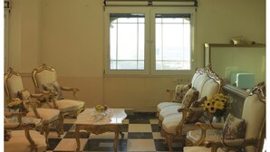 A room with ornate ceiling, checkered floor, and classic furniture. - Hotel Esperides (Naxos)