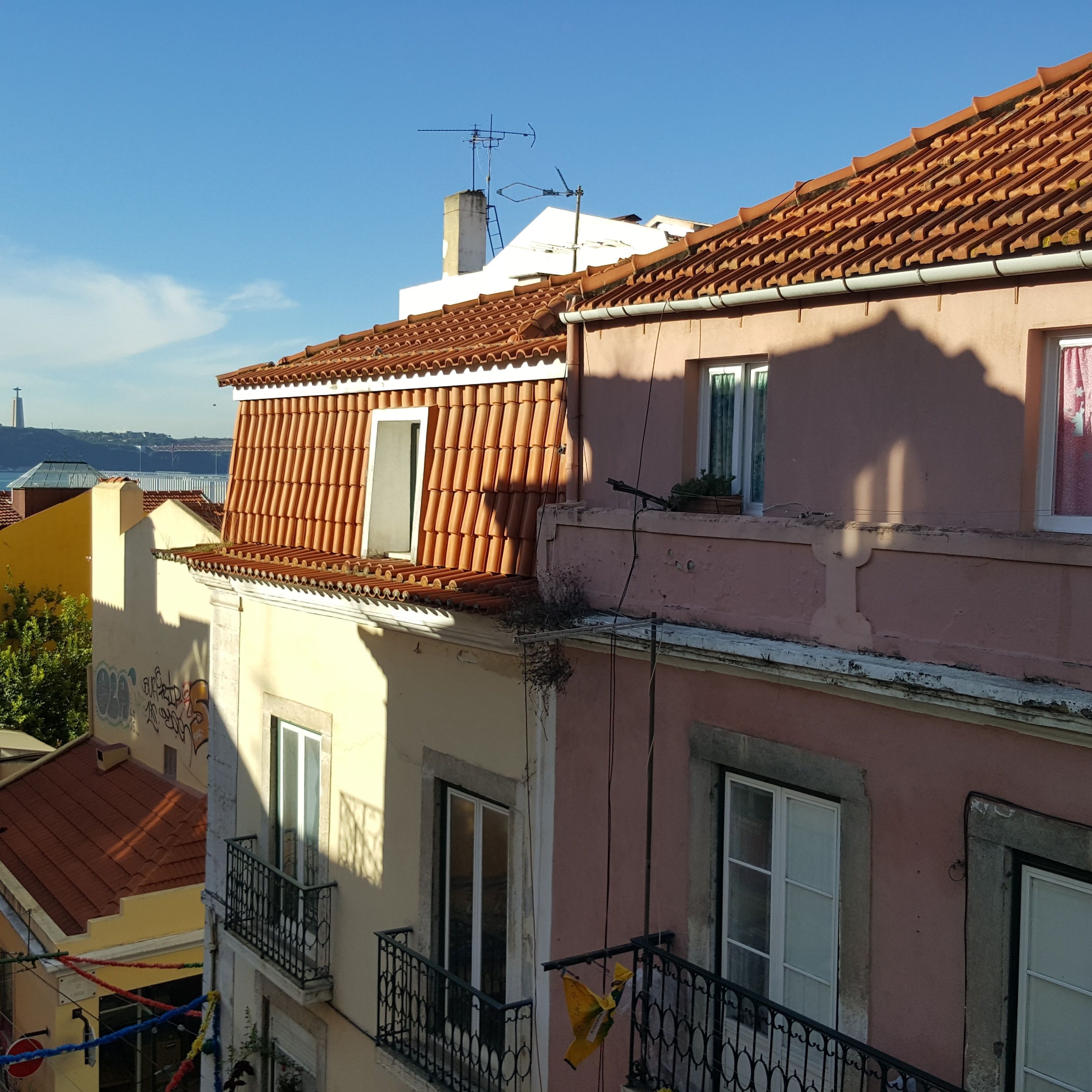A multi-story building with red-tiled roofs and balconies.