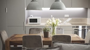 A modern kitchen with a dining table, chairs, and a potted plant. - City Stays Bica Apartments (Lisbon)