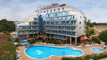 A modern hotel with multiple floors, a central courtyard, and a swimming pool.