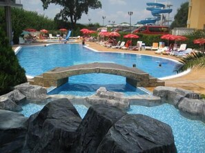 Una piscina al aire libre, sillones reclinables de piscina