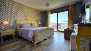 A bedroom with a bed, nightstands, a dresser, and a chair. - Nilufer Otel - Adult Only (Ayvalik)